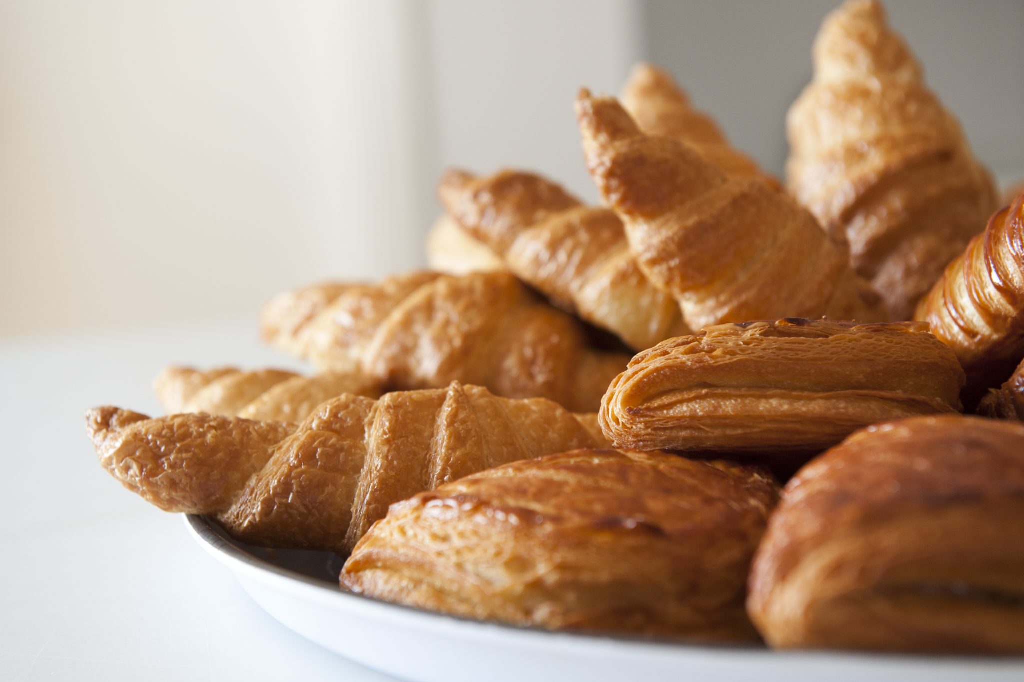 Croissants and small pastries on a tray.